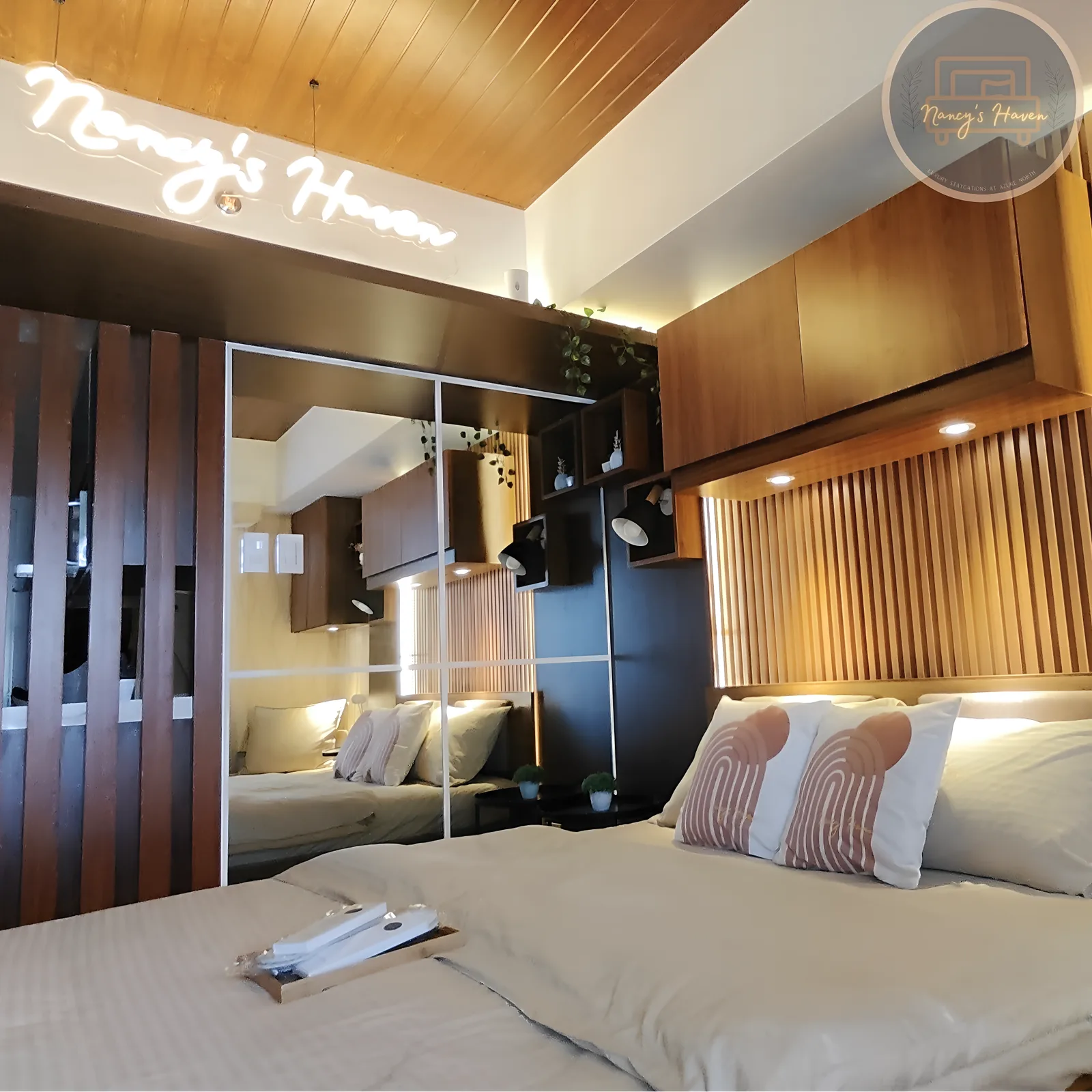 A styled bedroom at Nancy's Haven beneath the signature neon sign
